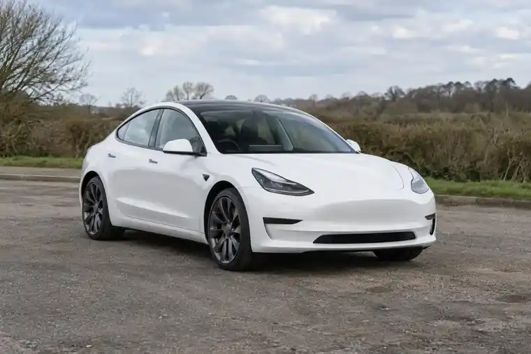 Illustration of a white electric car in a roadside layby