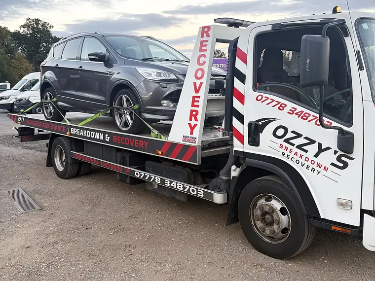 SUV on Ozzy’s Breakdown Recovery truck at sunset